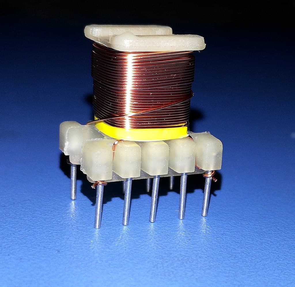A wound ferrite transformer bobbin with yellow insulation tape